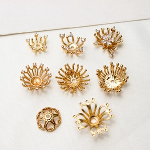 Vue macro de 8 coupelles et intercalaires fleurs dorés avec zircons pour bijoux