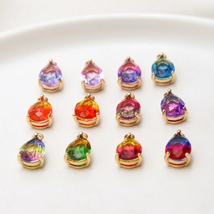 Detailed view of 12 gradient glass water drop charms with gold plated copper borders