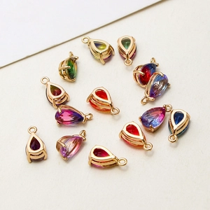 Macro view of teardrop glass pendants with gold-plated frames for DIY jewelry