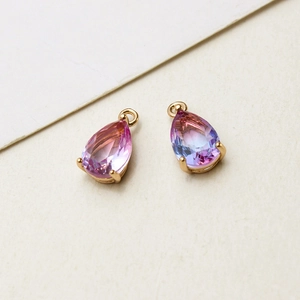 Close-up of gold-plated waterdrop pendants with pink-purple gradient glass for DIY jewelry