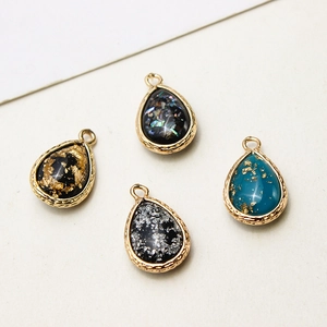 Detail of tear-drop resin pendants with gold-plated copper edges for DIY jewelry making