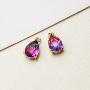 Detailed macro view of gold-plated teardrop pendant with blue-purple gradient glass