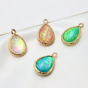 Detailed macro view of four teardrop opal pendants with gold textured metallic edges