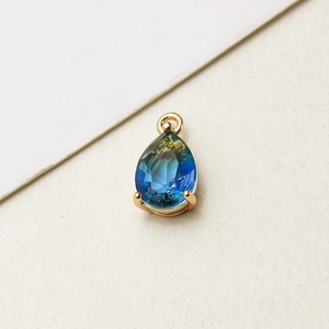Detailed view of teardrop gradient glass pendant with gold-plated three-prong setting
