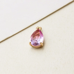 Detail view of pear-shaped gradient glass pendant with gold-plated copper bezel setting