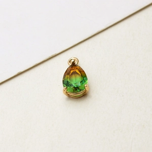 Macro shot of gold-plated pear-shaped gradient glass pendant with four-prong setting