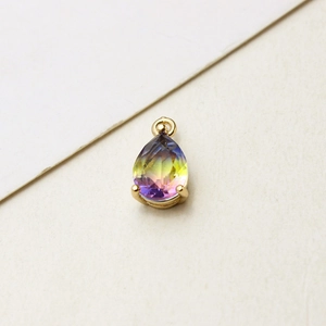 Macro detail of teardrop pear-cut glass pendant with gold-plated four-prong setting