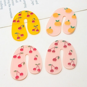 Detail of U-shaped acrylic cherry and orange charms for DIY earrings and necklaces