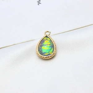 Macro detail of gold-plated waterdrop opal pendant with intricate wavy metallic edges