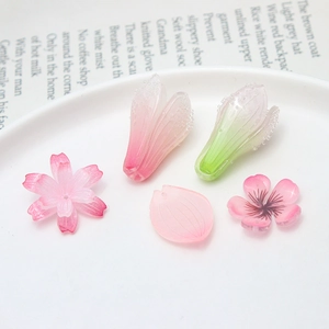 Pièces bijoux DIY avec fleurs de cerisier et pétales en résine rose givrée sur magazine