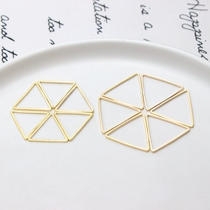 Détail macro de breloques triangulaires plaquées or pour la création de bijoux DIY