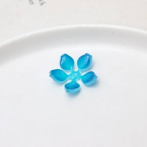 Gros plan d'un charme floral en résine bleue avec pétales dégradés pour bijoux DIY