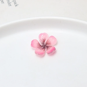 Gros plan de pendentifs fleur de cerisier rose dégradé avec trou pour bijoux DIY