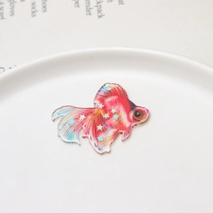 Macro detail of acrylic goldfish pendant with colorful sequins for DIY jewelry making