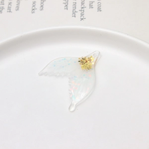 Detail of DIY transparent resin butterfly wing pendant with iridescent sequins