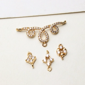 Close-up of gold-plated geometric rhombus connectors with sparkling cubic zirconia