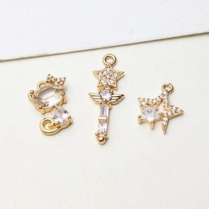 Macro shot of gold-plated cat and star fairy wand pendants with zircon inlay