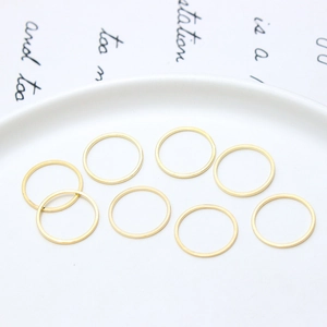 Nahaufnahme minimalistischer vergoldeter geometrischer Creolen auf weißem Keramiktablett