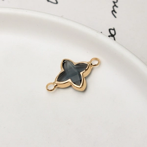 Macro detail of gold-plated clover and star charms with gray stones for DIY jewelry