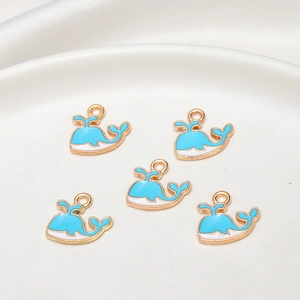 Macro view of five blue and white whale alloy pendants on a clean white porcelain tray