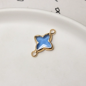 Macro shot of gold-plated four-pointed star pendant with blue resin and dual loops