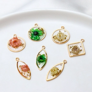 Handmade gold plated geometric resin pendants with dried flowers and gold leaf foil