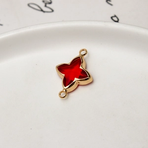 Detailed macro of a gold-plated four-point star pendant with a red gemstone for DIY jewelry