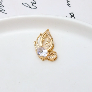 Makroaufnahme von Schmetterlingsanhänger in Gold mit ovalem Zirkonia auf Keramik