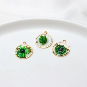 Detail of floral resin charms with gold foil and copper edges for DIY jewelry making