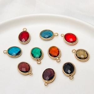 Macro view of multi-colored oval birthstone charms with gold frames for DIY jewelry