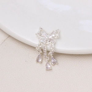 Dettaglio pendente a fiocco argento con zirconi micro-incastonati e nappe a goccia
