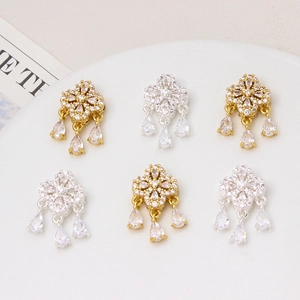 Detailed view of four-leaf clover charms with hanging water drop zircon stones in gold and silver
