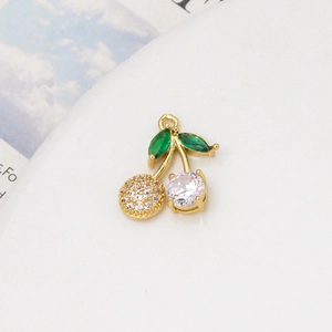 Macro shot of gold-plated cherry pendant with green and clear cubic zirconia stones