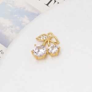 Macro shot of gold cherry pendant featuring micro-pave cubic zirconia on leaves and stones
