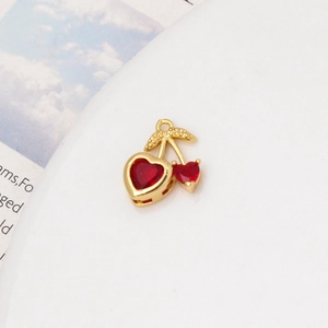 Detailed macro view of heart-shaped red cherry pendant with gold-plated metal and zircon