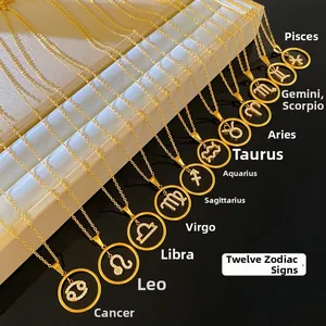 Detailed view of gold zodiac necklaces with sparkling crystal inlaid on creamy display stand