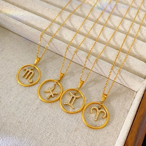Close-up of gold plated zodiac necklaces with crystal-studded constellation pendants