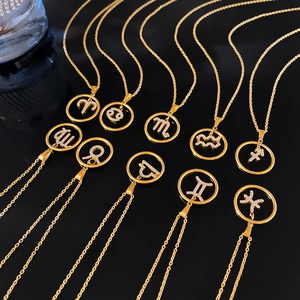 Gold plated zodiac pendant necklace with sparkling cubic zirconia on a black background