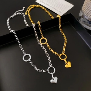 Dettaglio di collane lunghe con cuore in oro e argento con catena a maglie grandi e strass