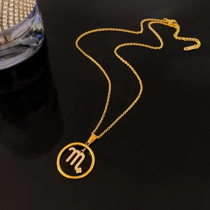 Gold plated Scorpio constellation necklace with white rhinestones on black background