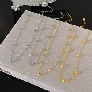 Elegant gold and silver Evil Eye necklaces with blue beads on gray velvet display