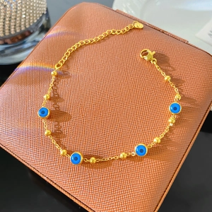 Détail de la chaîne dorée avec perles d'œil bleu maléfique et fermoir mousqueton réglable