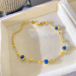 Détail du bracelet œil bleu doré avec fermoir mousqueton et chaîne de réglage