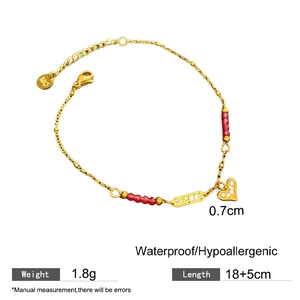 Golden titanium steel bracelet with red beads and LOVE heart charm on white background
