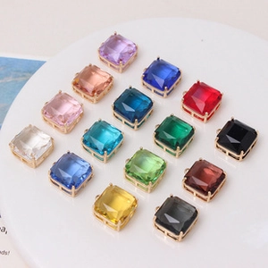 Macro view of multi-colored faceted square crystal pendants with gold-plated metal edges