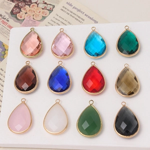 Detailed view of 12 faceted teardrop crystal pendants with gold plated metal edges