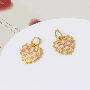 Macro detail of heart-shaped enamel pendants with pink and white checkerboard patterns