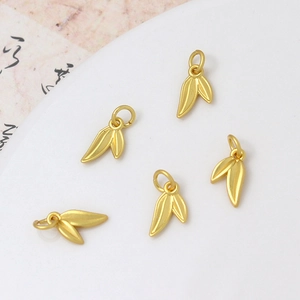 Detailed view of five golden bamboo leaf charms for DIY jewelry with matte finish