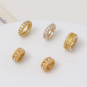Detalle de cuentas espaciadoras doradas con circonitas y perlas para joyas DIY