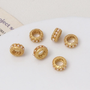Vista macro de 6 cuentas espaciadoras de oro mate con perlas para joyería artesanal DIY